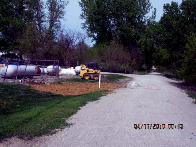 Dick Arnold used a skid loader to distribute black dirt on the eastern approach trail.