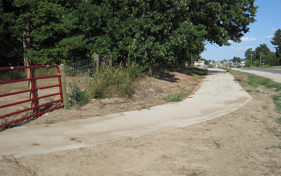 The Loop Trail emerges from Whitham Woods onto a concrete trail along Burlington Ave.