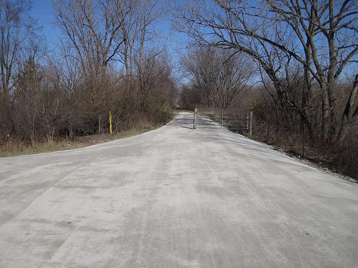 The posts keep out motorized vehicles.   To the left is a small parking lot