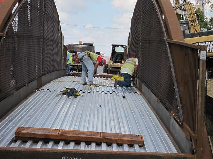 The deck is being fastened in place.  Concrete will be poured on it after the bridge is in place.