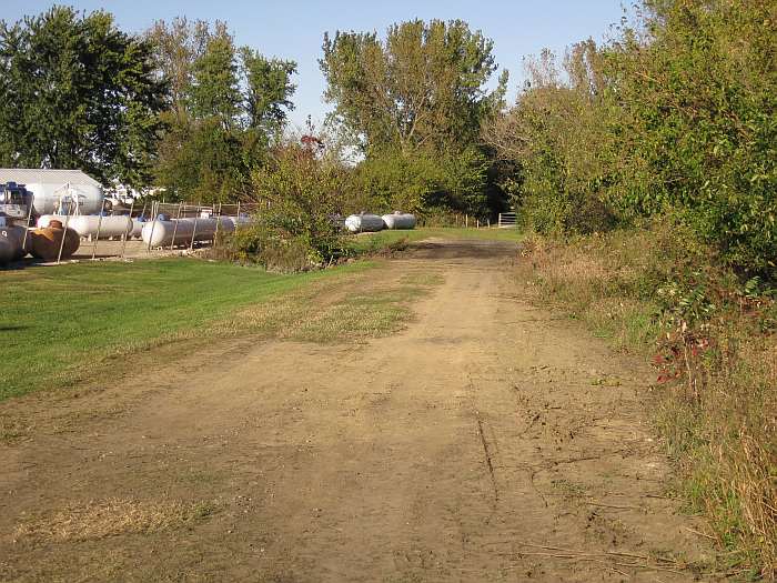 The old railroad roadbed, looking east behind Ferrellgas.   Note the gate to the existing trail up ahead