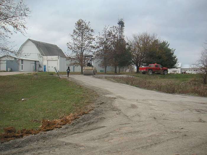 A roller was used to pack down the stone surface.   The parking lot is to the right of the roller.