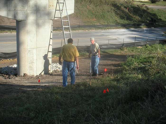 Now that the bridge is in place, the approaches must be built. Dick Reed and Jim Salts stake out the positions for the approach support poles