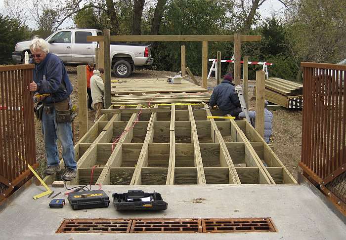 10/11/09.   The holes being drilled into the bridge fence will receive the railing